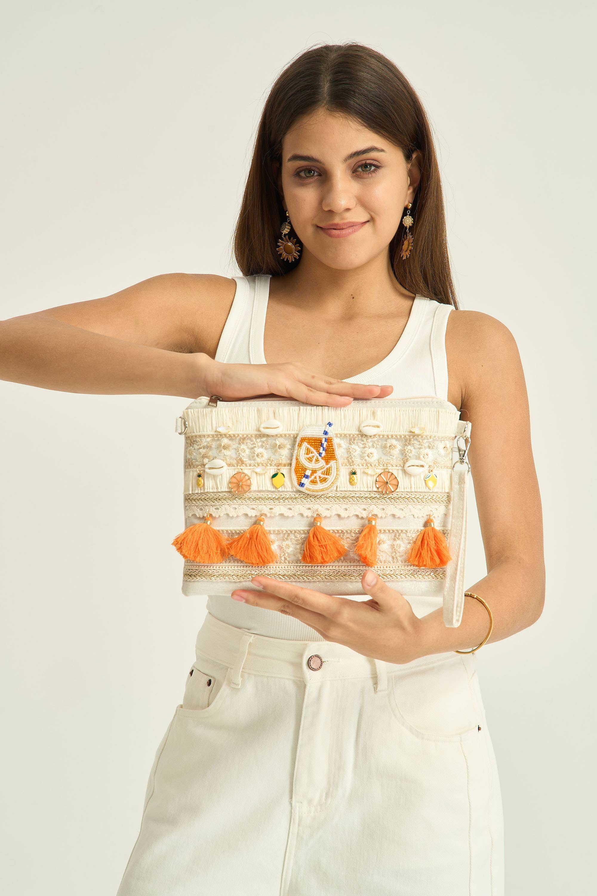 Pochette bohème écru beige brodée avec pompons orange